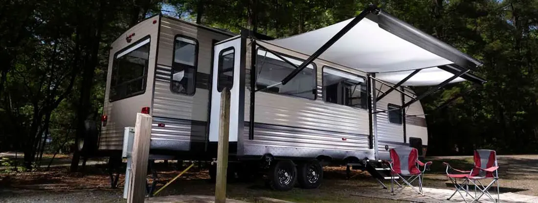 Awnings out on an RV at a campsite. Find Fifth Wheel Trailer Insurance.