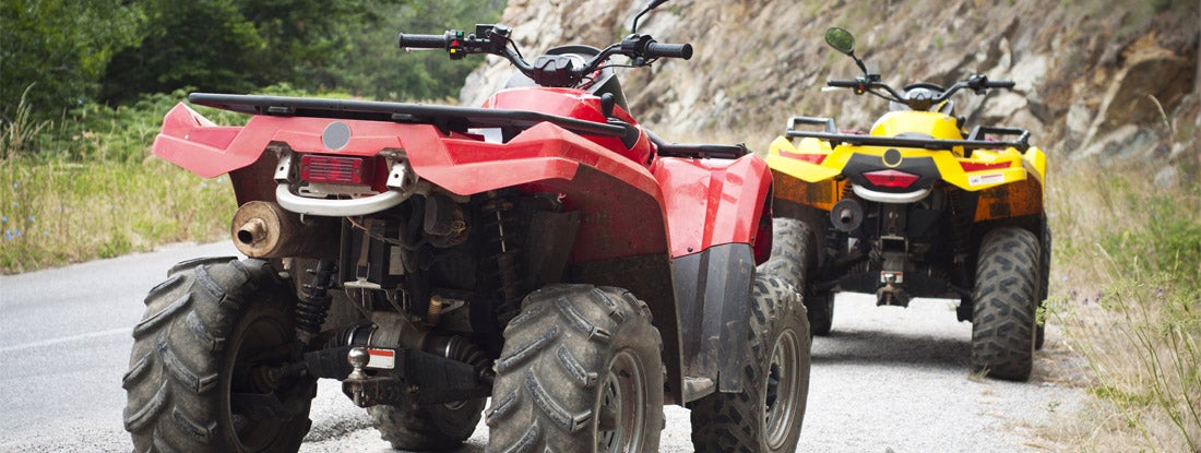 Red and yellow atv parked at forest road