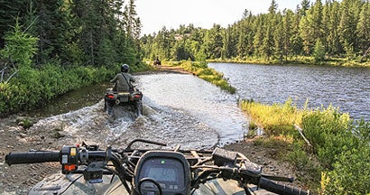 People driving ATV quads through water. Find ATV Insurance.