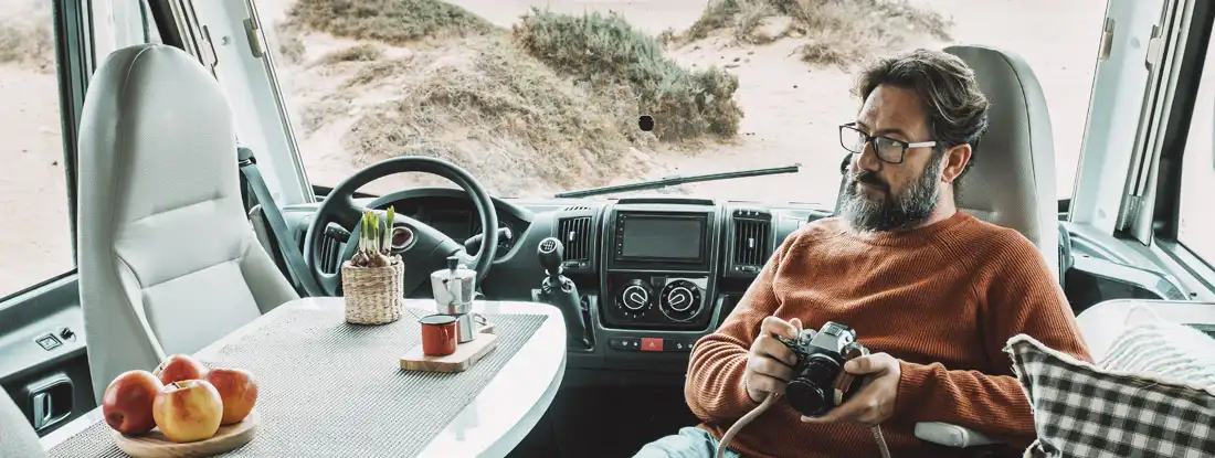 Man sitting and relaxing inside an RV. Find RV Liability Insurance.