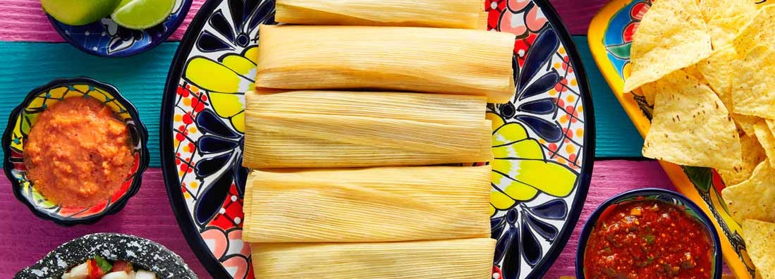 Tamale with corn leaf and sauces guacamole