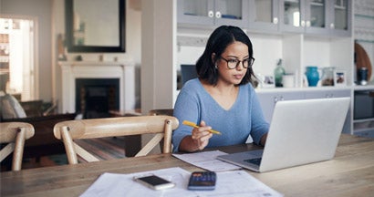 Woman using a laptop at home.  Understanding Home Insurance Claims.