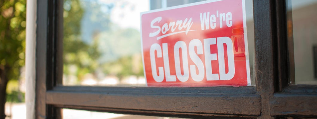 Closed sign in store window front. Find Business Interruption Insurance.