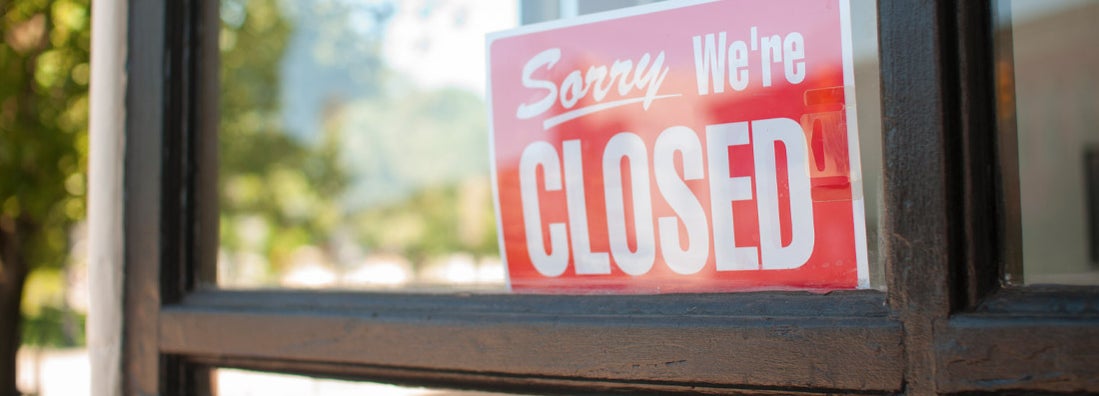 Closed sign in store window front. Find Business Interruption Insurance.