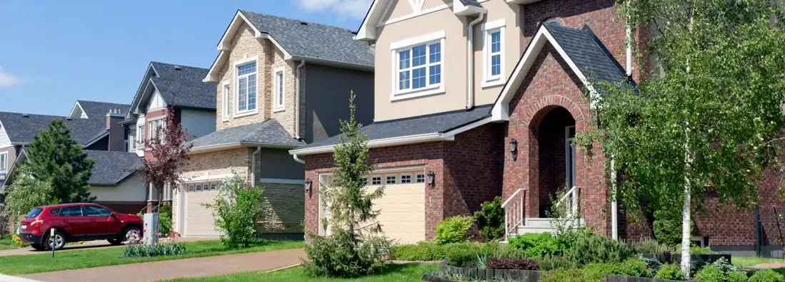 Brand new suburban houses in sunny summer afternoon. Find North Dakota umbrella insurance.