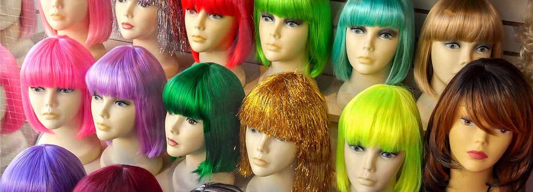 Mannequins Wearing Colorful Wigs in Window of a Wig Shop
