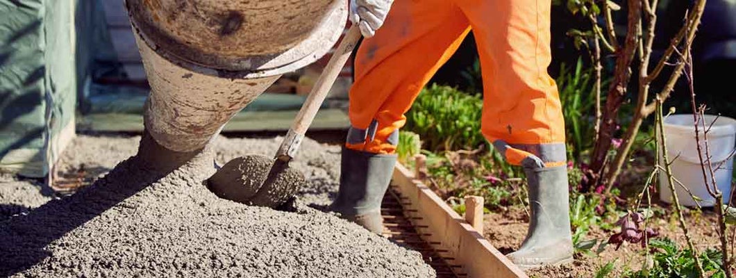 Worker spreading ready mix concrete. Find Concrete Contractors Insurance.