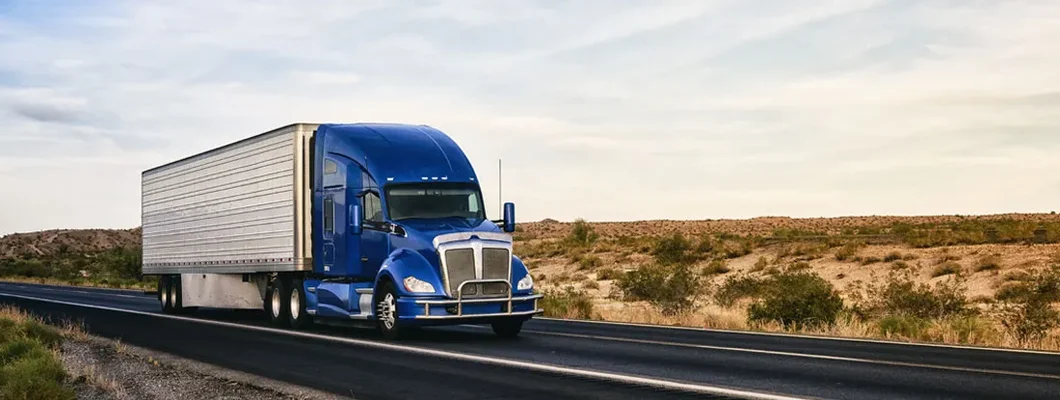 Semi truck on highway through desert in New Mexico. Find Commercial Truck Insurance.