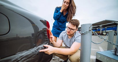 Man and woman examining damage in car collision. Find Collision Insurance.