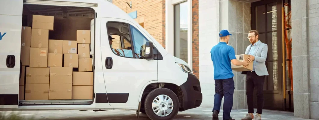 Delivery Man Gives Postal Package to a Business Customer. Find Arkansas Commercial Vehicle Insurance.