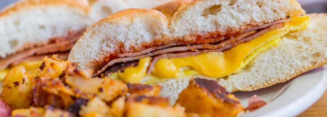 Taylor ham, pork roll, egg and cheese breakfast sandwich with home fries from New Jersey