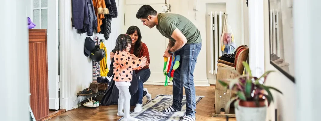 Mother putting jacket on daughter in mudroom. How to Find the Best Homeowners Insurance in Lenexa, Kansas.