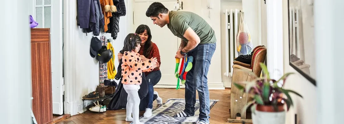 Mother putting jacket on daughter in mudroom. How to Find the Best Homeowners Insurance in Lenexa, Kansas.