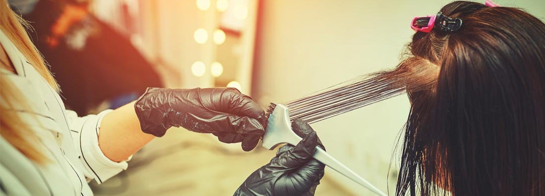 Woman gets new hair color at the salon from hairdresser