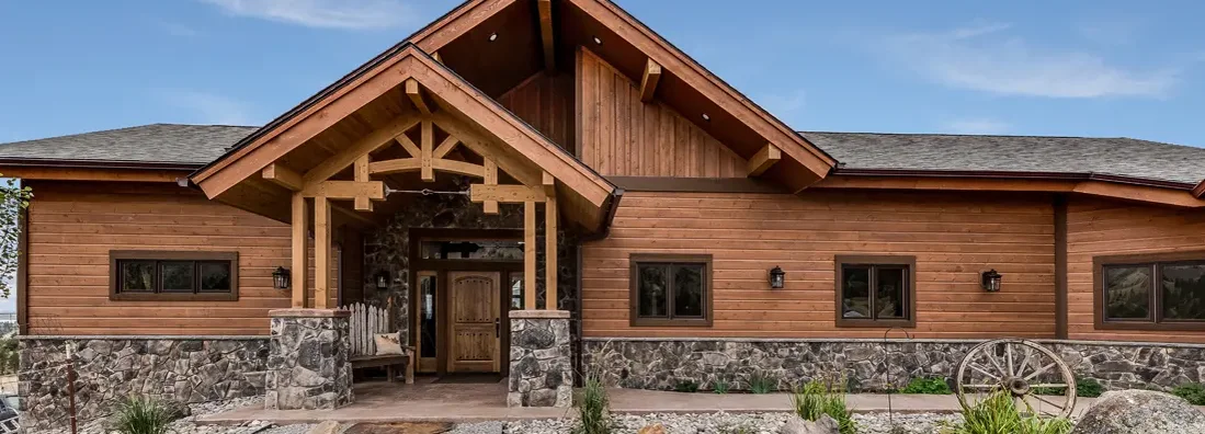 All wood facade with many rocks and stones surrounding the home. Williston, North Dakota Homeowners Insurance. 