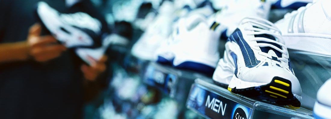 young man looking at shoes in a running shoe store