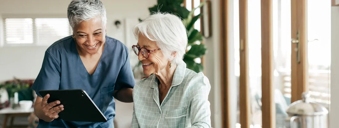 Compassionate nurse helping an elderly woman understand her healthcare options. Longevity Insurance.