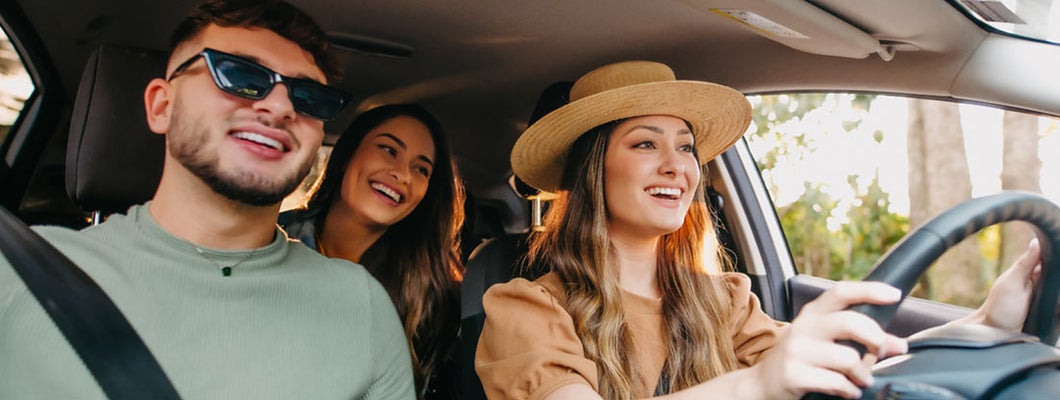 Happy friends traveling by car. Find Lincoln Nebraska car insurance.