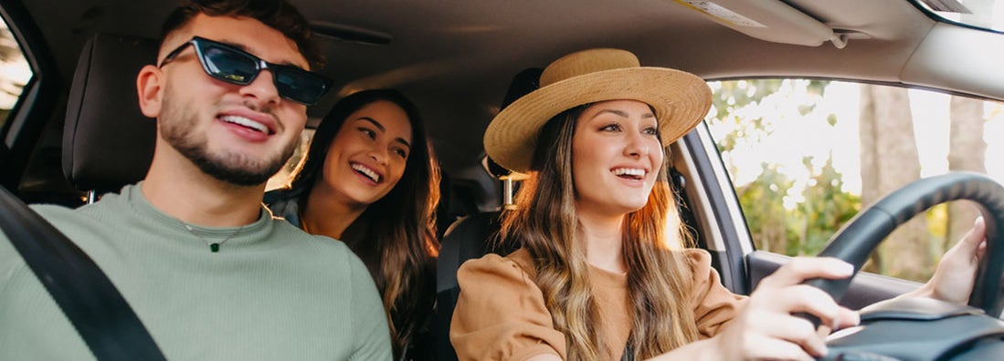 Happy friends traveling by car. Find Lincoln Nebraska car insurance.