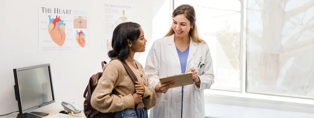 Female doctor talks to female college student. Doctor and Patient Confidentiality for Teens and Adolescents.