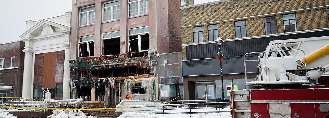 Storefront of a business sits the morning after the fire. Find small business hazard insurance.