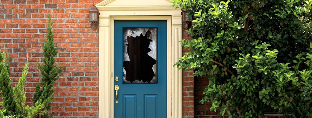 close up shot of broken door window glass of brick house