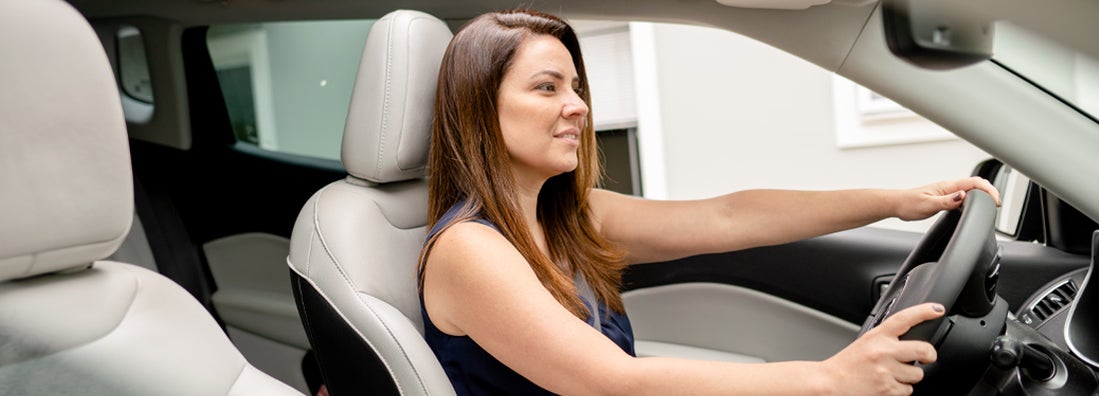 Woman sitting in the driver's seat of an SUV. Find Prairie Village, Kansas car insurance.
