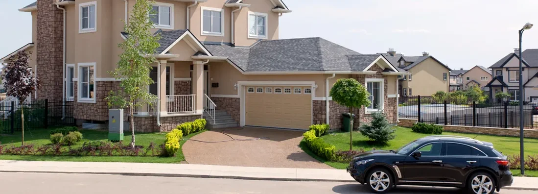 Brand new suburban house and car parked on street on a sunny summer afternoon. Find Tennessee umbrella insurance.