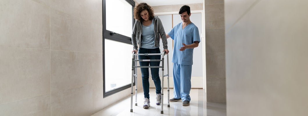 Patient using a walker recovering from a physical injury and nurse behind her helping at the hospital. How Long Does Individual Short-Term Disability Insurance Last?