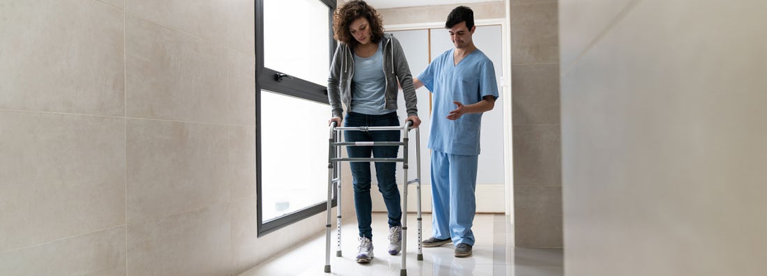 Patient using a walker recovering from a physical injury and nurse behind her helping at the hospital. How Long Does Individual Short-Term Disability Insurance Last?