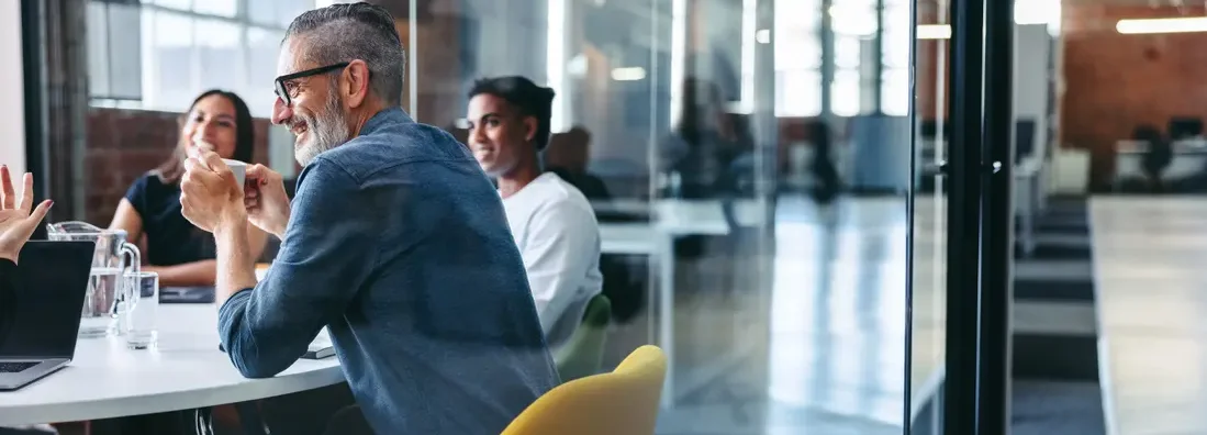 Businessman attending a meeting with his team. Find Northbrook, Illinois business insurance.