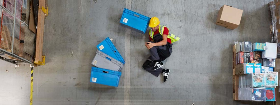 Man lying on the floor. Accident in warehouse