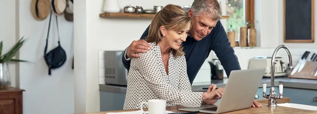 A senior couple researching car insurance using a laptop at home. How to shop for car insurance.