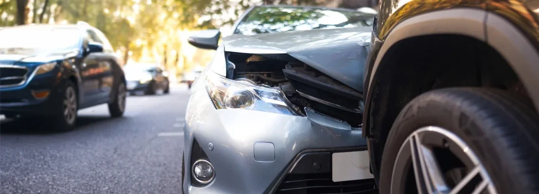 Two damaged vehicles in car accident after collision on city street. Find Collision Insurance.