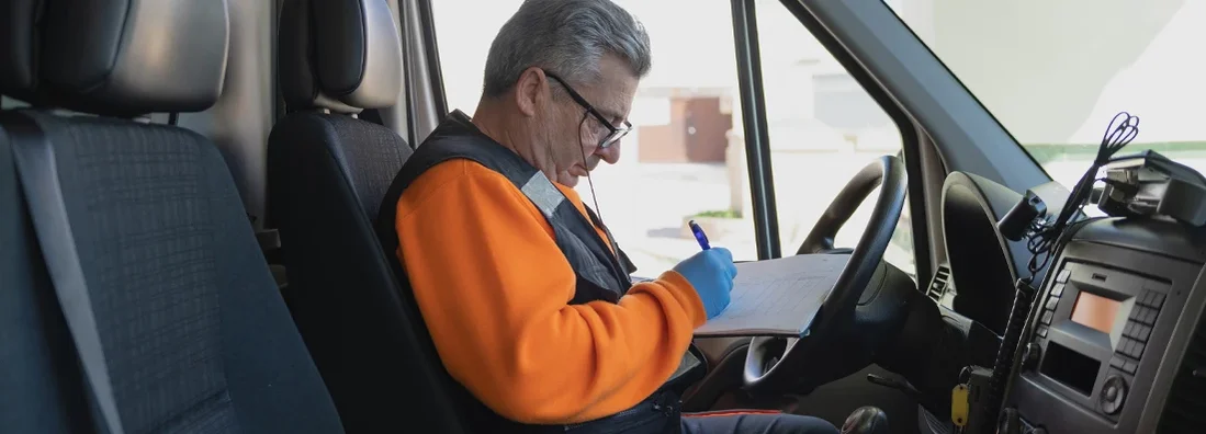 Paramedic writing on a paper in a work van. Rhode Island Commercial Vehicle Insurance.