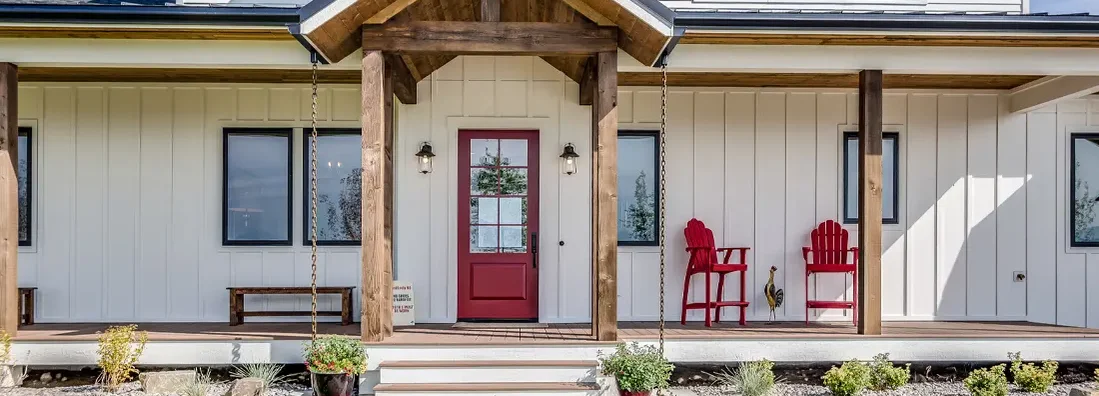 Black trim windows and red front door on white house. How to Find the Best Homeowners Insurance in Prairie Village, Kansas.