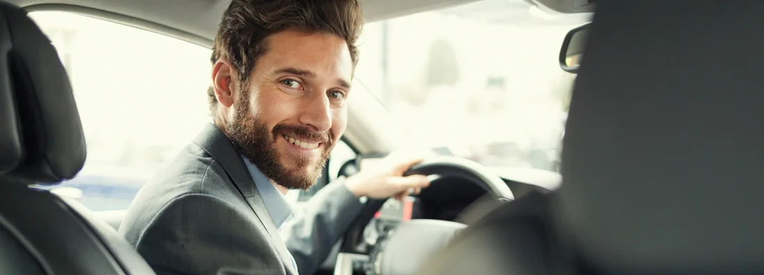 Handsome man in his car driving. Pleasure use vs commuter car insurance.