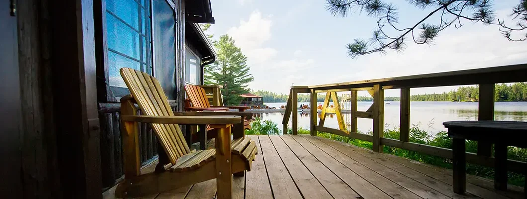 Muskoka chairs on a wooden deck of lake house. Find Lake Oswego, Oregon homeowners insurance.