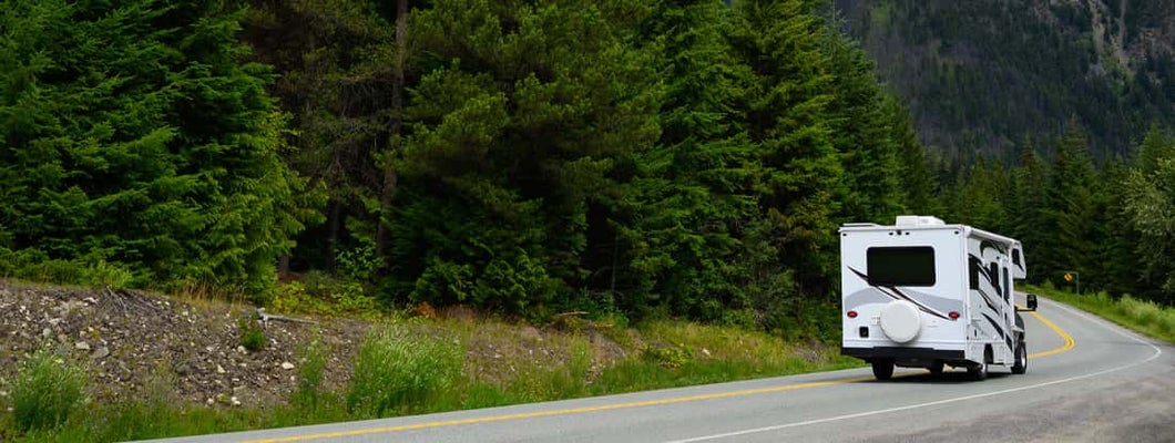 Motor home on road with mountains in background. Find Oregon RV Insurance.