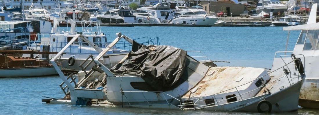 Sunken boat on the pier. Find vandalism to your boat at the marina.