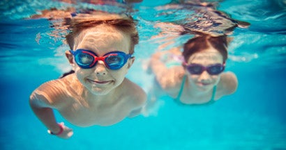 Kids swimming underwater in pool. 6 Fascinating Facts You Might Not Know About Pool Liability.