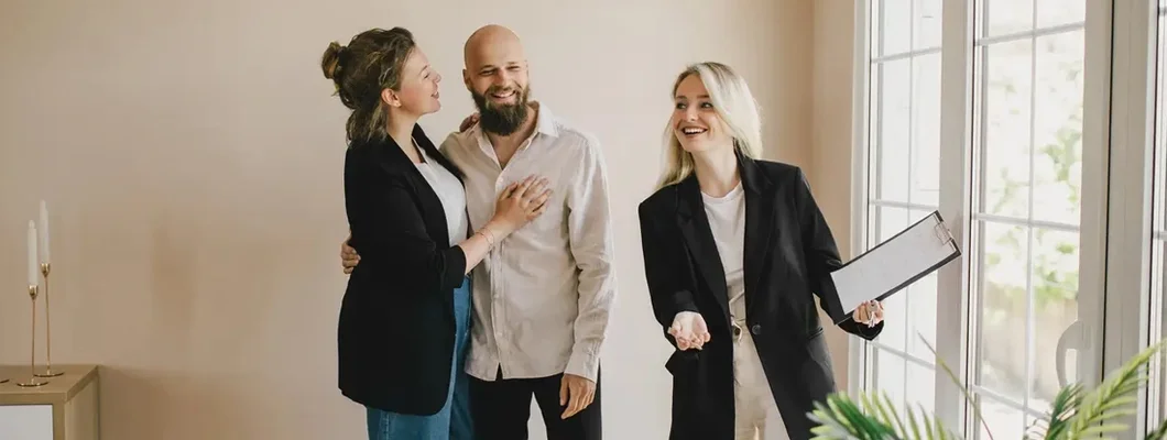 Real estate agent demonstrating a new apartment to a happy couple. Find New Mexico Landlord Insurance.