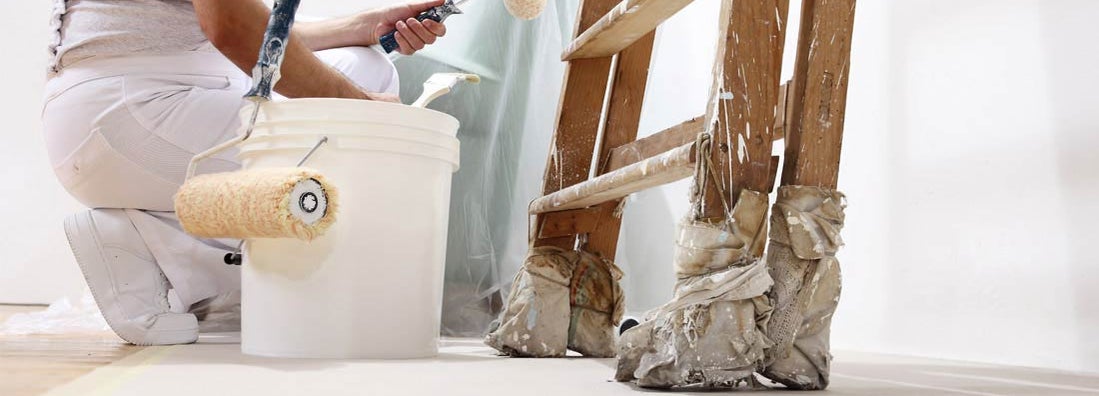 Painter painting a white wall. Find Painting Business Insurance.