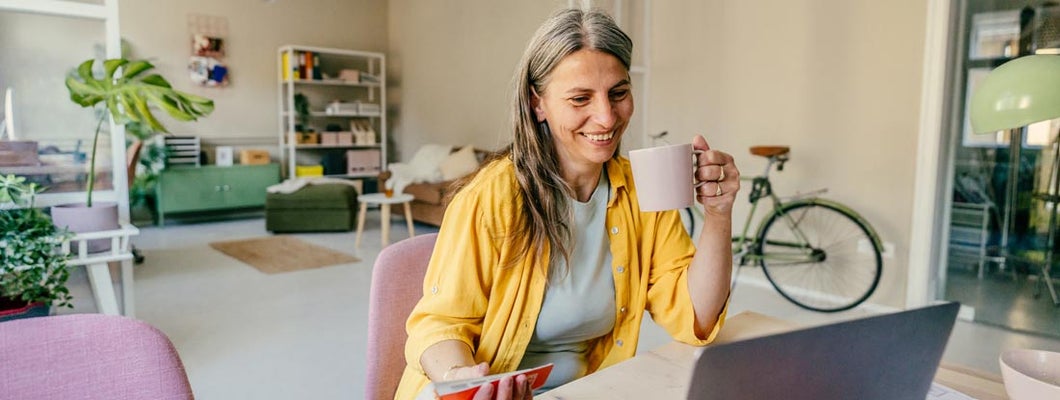 Smiling woman working from home. Find Sioux Falls, South Dakota renters insurance.