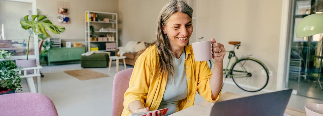 Smiling woman working from home. Find Sioux Falls, South Dakota renters insurance.