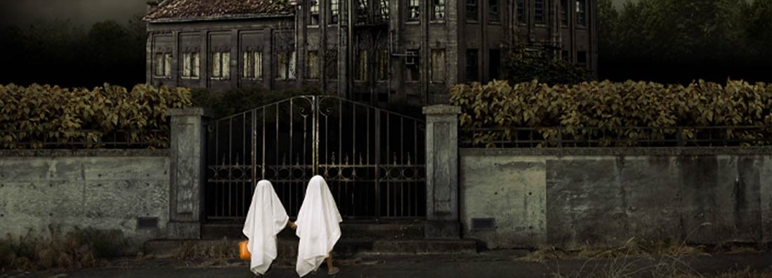 Children in Ghost Costumes Trick or Treat at Haunted House