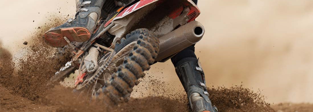 Rider driving in the motocross race the rear wheel motocross bike. Find Dirt Bike Insurance.