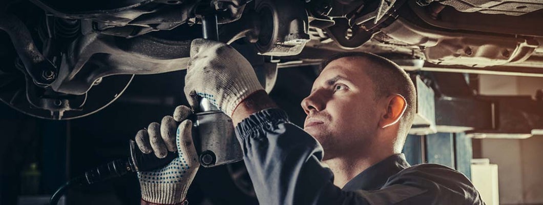 Professional mechanic repairing a car in auto repair shop. Find Auto Repair Shop Insurance.