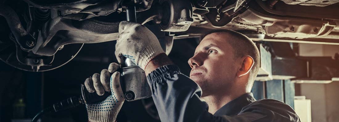 Professional mechanic repairing a car in auto repair shop. Find Auto Repair Shop Insurance.