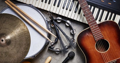 Group of musical instruments including a guitar, drum, keyboard, tambourine. Find Musical Instrument Insurance.